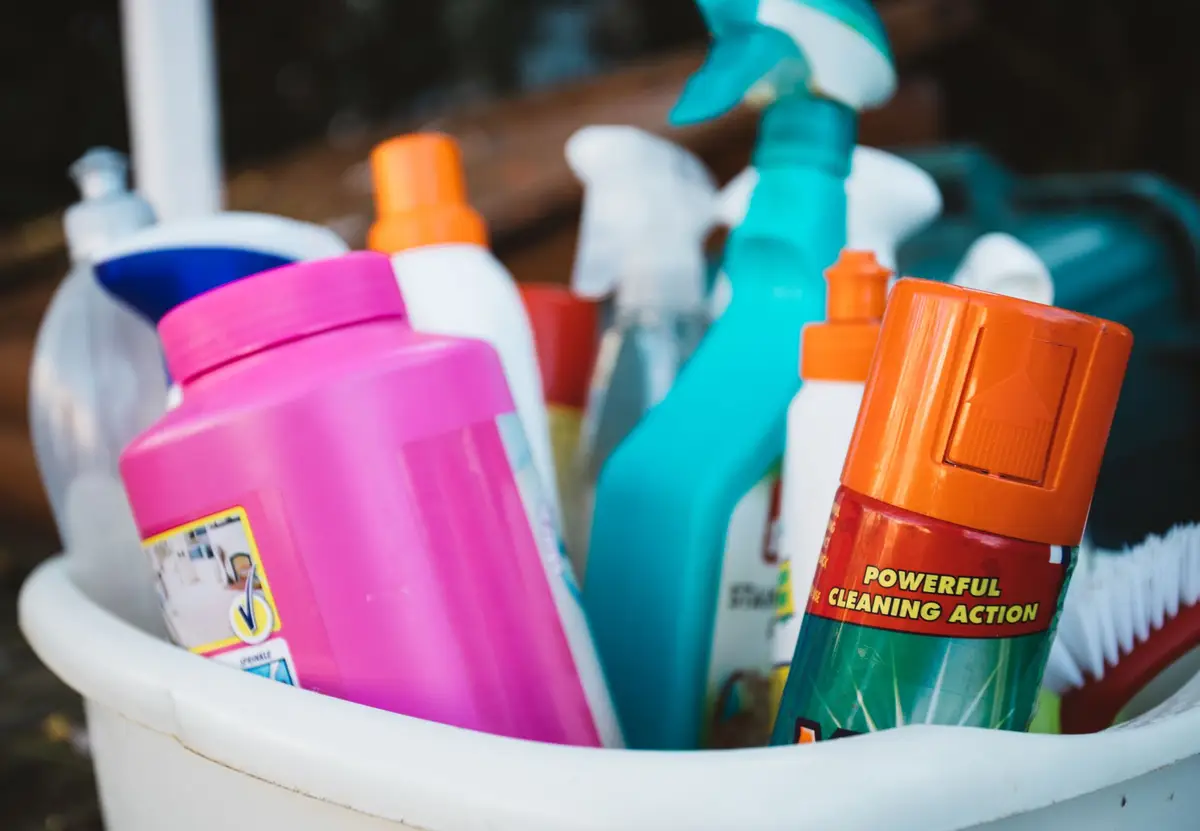 A bucket of professional cleaning supplies and spray bottles